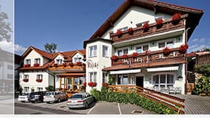A traditional European hotel with a central staircase, multiple balconies, and a parking area. - Hotel Rajsky (Cesky Krumlov)