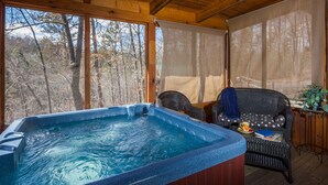 Un jacuzzi en una cabaña de madera con vistas a árboles.
