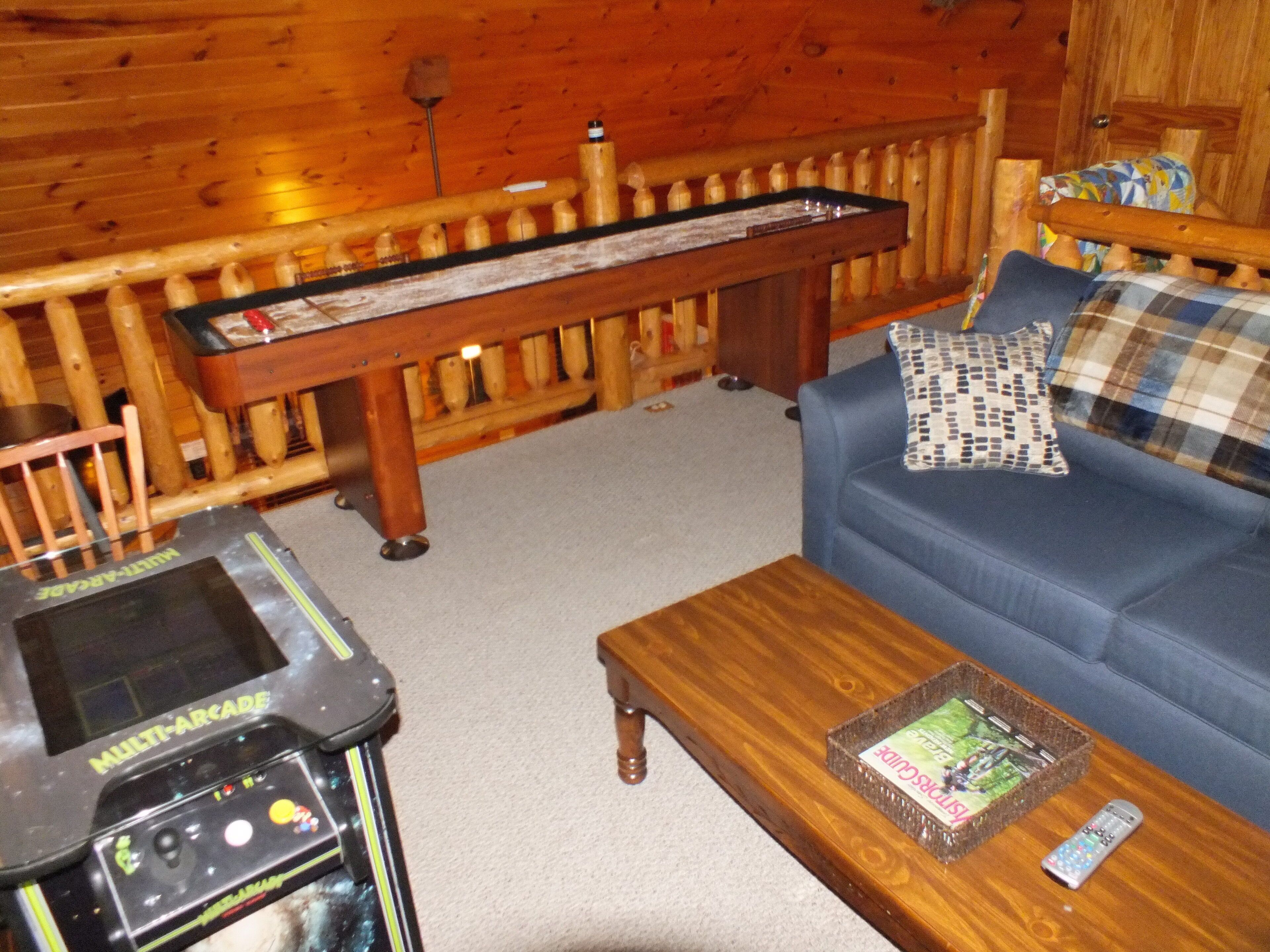 A cozy cabin interior with a wooden bench, a blue sofa, and a coffee table.