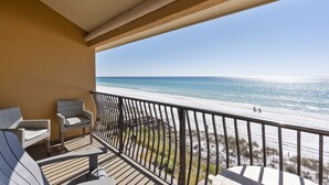 A balcony with wicker chairs and a view of the beach. - 44- Gorgeous BEACH FRONT Condo with Loft in Crystal Beach. Coral Reef Club (Destin)