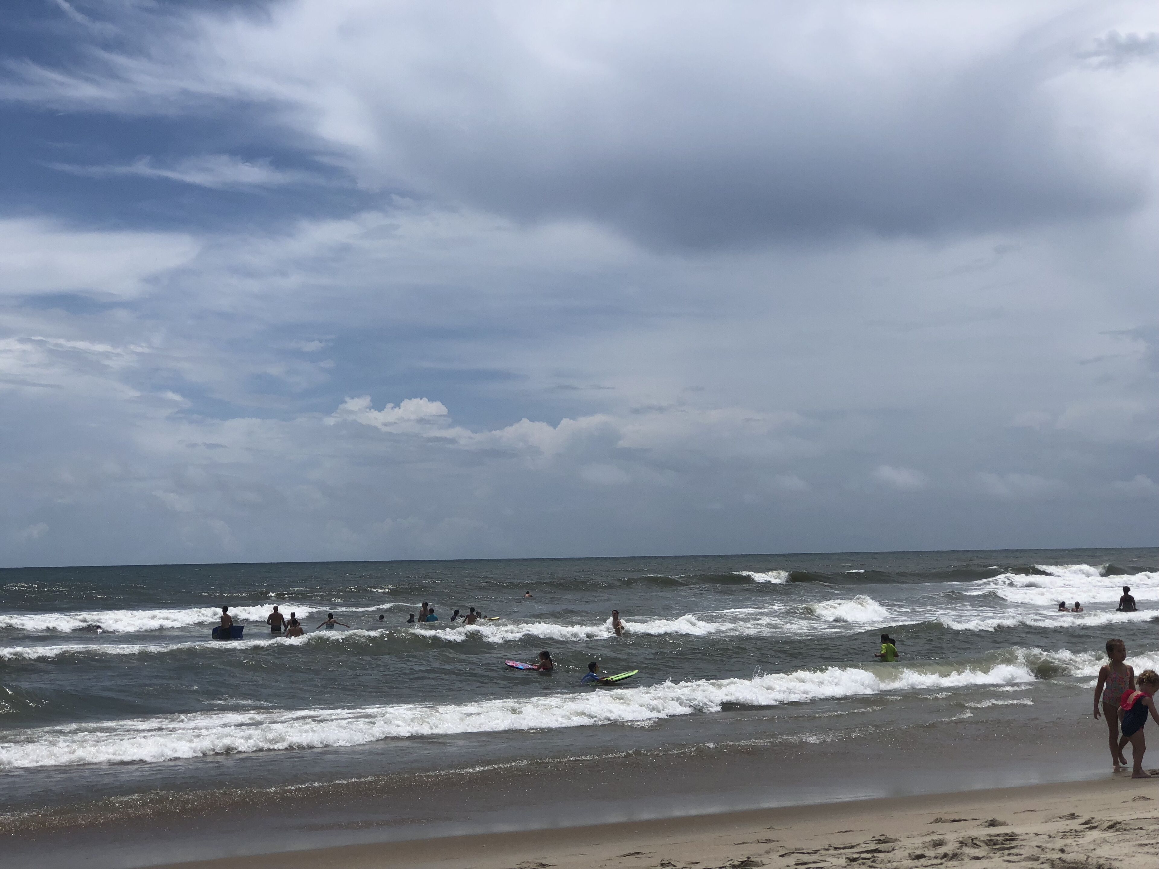 A beach with waves and people surfing.