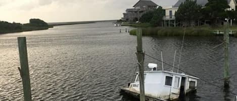 A dock with a small boat, a wooden pier, and a building in the background.