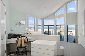 Enjoy a productive stay with a desk area offering a beach view, a comfortable seating area, and a chest of drawers.