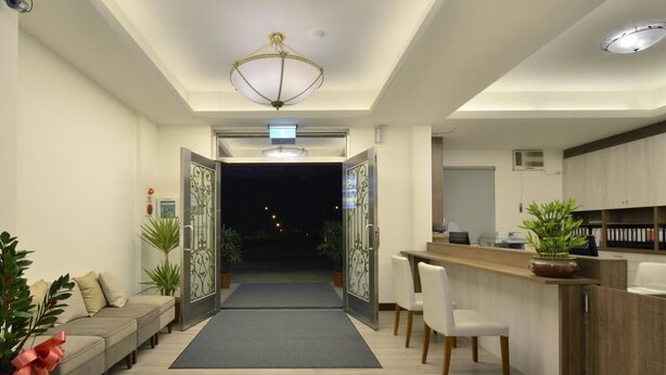 A modern interior with a reception desk, seating area, and a kitchen. - Hoya Resort Hotel Chiayi (Minxiong)