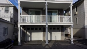 Ein zweigeschossiges Wohnhaus mit Balkon, Garage und Auffahrt.