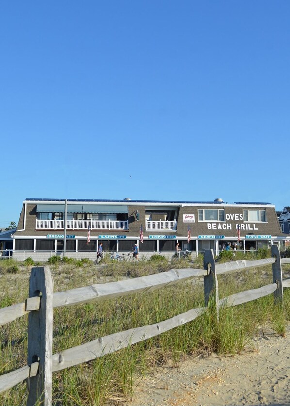 Un edificio frente a la playa con secciones identificadas para desayuno, almuerzo, cena, mariscos y comida para llevar.