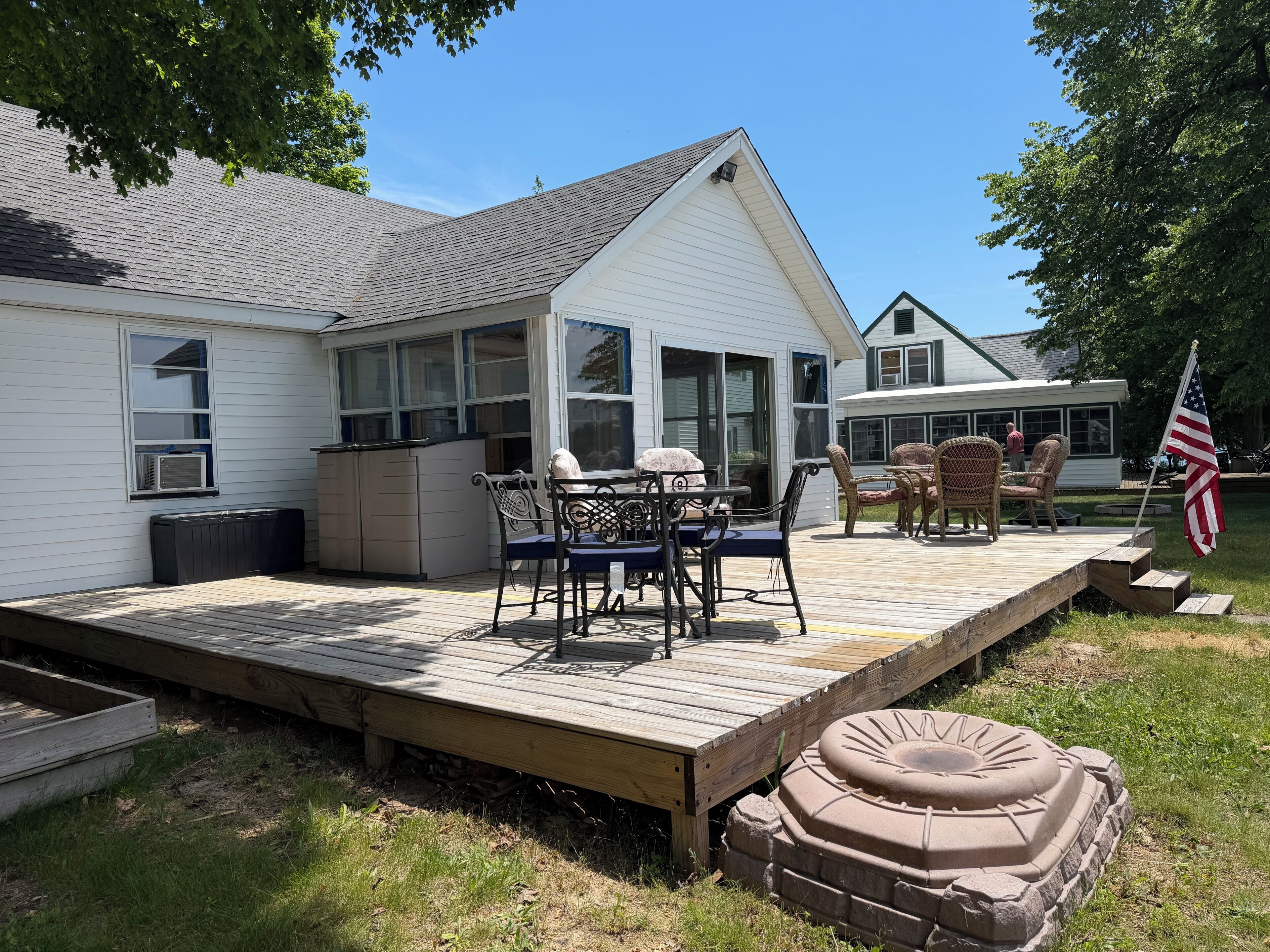 A house with a covered patio, outdoor furniture, and an American flag.