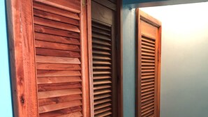 Un couloir avec des portes en bois et une source de lumière au fond.