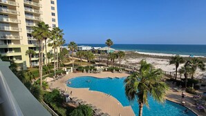 A resort with a swimming pool, beach, and ocean view.