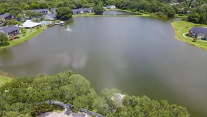 Vue aérienne d’un lac entouré de propriétés résidentielles, d’une zone de baignade et d’un quai.