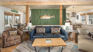 Een gezellige woonkamer met een blauwe bank, een gestreept fauteuil en een houten salontafel.