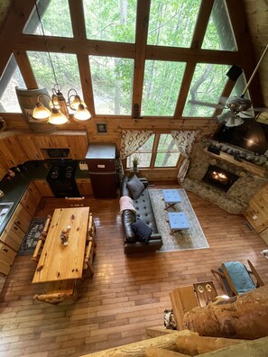 Ein gemütliches Blockhaus-Interieur mit Esstisch, Sofa und Kamin.
