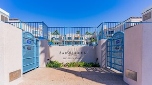 A gated entrance to a hotel named 'San Miguel' with a clear view of the surrounding buildings and palm trees. - Ocean Front Condo With Pool and Jacuzzi!!! (Oceanside)