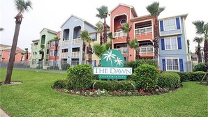 Eine Reihe bunter Eigentumswohnungen mit einem Schild, auf dem "The Dawn Condominiums" steht.
