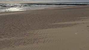 Une plage avec une vaste étendue de sable et une mer calme.
