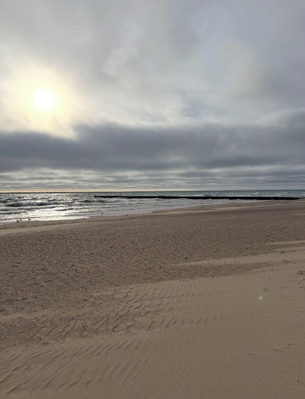 Een strand met een groot zandgebied en een kalme zee.