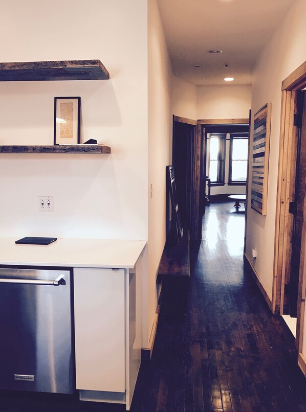 A kitchen with a built-in refrigerator, wooden shelves, and a countertop. - The entire FLAT. Stay Like You Own! Central AIR. TWO FULL BATHROOMS. Unique. (Chicago)