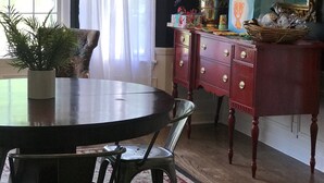 A dining room with a chandelier, a round table, chairs, a red dresser, and a mirror. - Gorgeous Private Countryside Getaway! (South Bend)