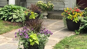 A house with a porch, potted plants, a bench, and a flag. - Gorgeous Private Countryside Getaway! (South Bend)