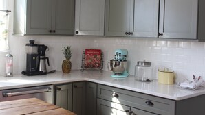 A kitchen with white cabinets, a coffee maker, a mixer, and a cookbook on the counter. - Gorgeous Private Countryside Getaway! (South Bend)