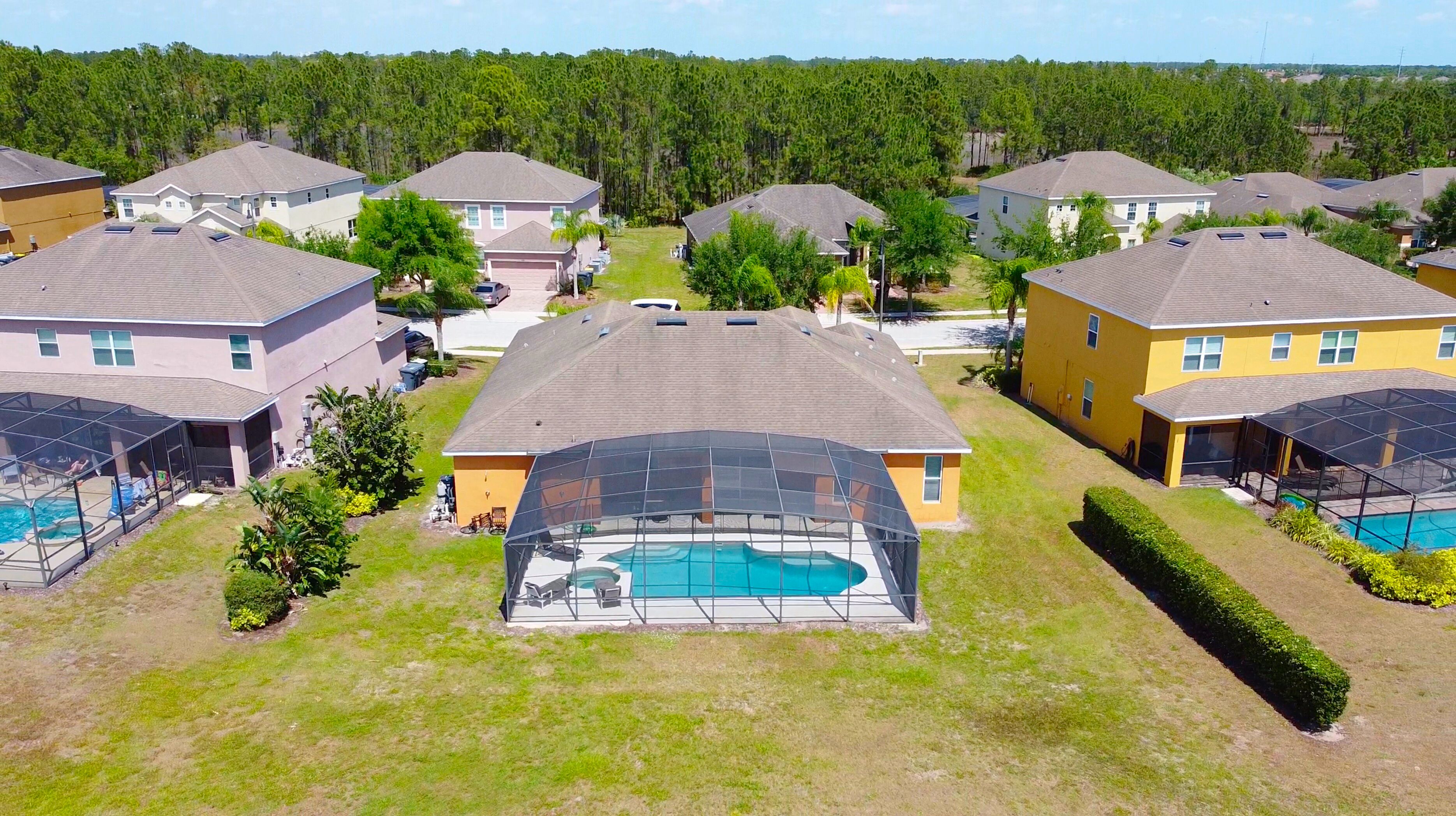 Un barrio residencial con varias casas, una piscina y un área de patio techada.