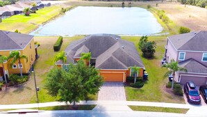 A residential area with houses, a large pond, and a clear sky.