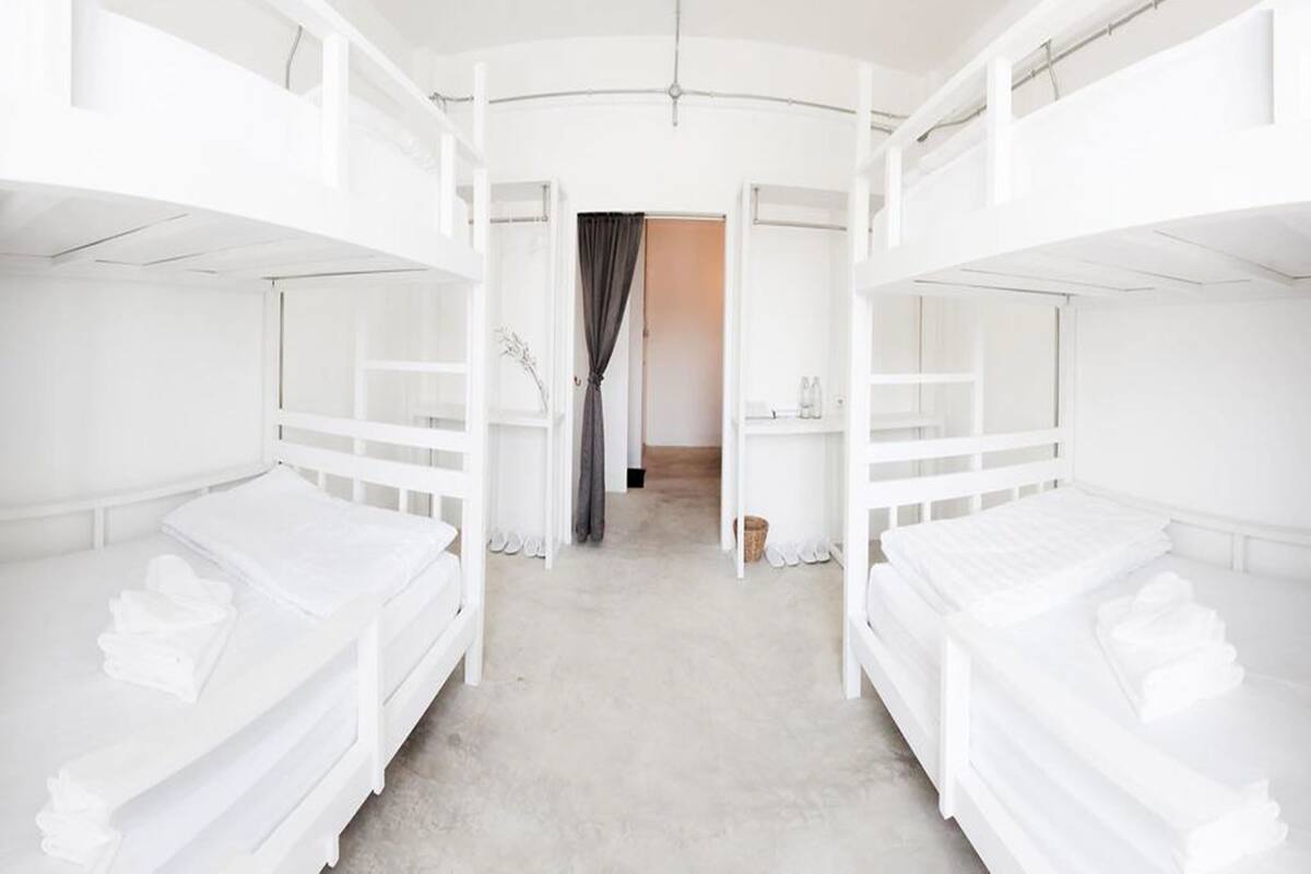 Ein Zimmer mit Etagenbetten, einem kleinen Schreibtisch und einem Stuhl.