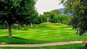 A golf course with a well-maintained green, a sand bunker, and a walking path. - Family-friendly Golf Course Home near Purgatory. Hot Tub,  BBQ. April Special. (Durango)