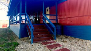 A building with a blue exterior and a red section, featuring a staircase leading to a covered porch area. - WW, Kentucky Lake, Bass Fish, Nashville, MEMPHIS, Birdsong Marina, Paris Landing (Camden)
