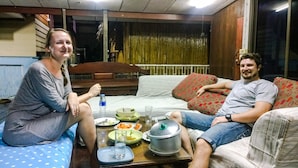 A room with a bed, a dining table with plates, glasses, and a water bottle. - Cast Away  Homestay (Pak Kret)