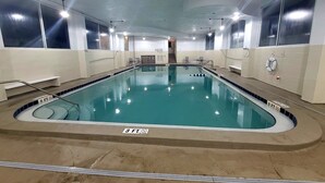 An indoor swimming pool with clear water, marked depth indicators, and safety railings. - Salty Kisses OCEANFRONT Daytona Beach studio condo (Daytona Beach)