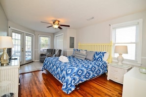 A bedroom with a bed, a ceiling fan, a nightstand, and a window with blinds. - Decked Out Ocean Inlet House Private Pool Tiki Hut (North Myrtle Beach)