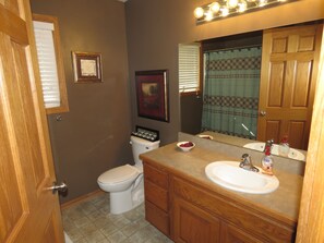 A bathroom with a toilet, sink, and mirror. There is a framed certificate on the wall and a bowl of fruit on the counter. - Beautiful 3 BR home with easy access to I-80 and 10 minutes to downtown. (Lincoln)