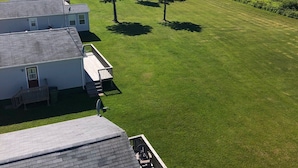 Una propiedad residencial con césped, una pequeña terraza y vista a un lago.