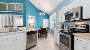 A modern kitchen with white cabinets, stainless steel appliances, and a blue accent wall. - Take a look at the reviews! Great value! An awesome place!!! Sleeps up to 16. (Kissimmee)