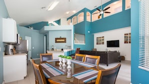 A modern kitchen with a dining area, a living room with a TV, and a ceiling fan. - Take a look at the reviews! Great value! An awesome place!!! Sleeps up to 16. (Kissimmee)