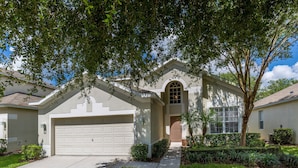 A residential house with a garage, a front entrance, and a well-maintained lawn. - Take a look at the reviews! Great value! An awesome place!!! Sleeps up to 16. (Kissimmee)
