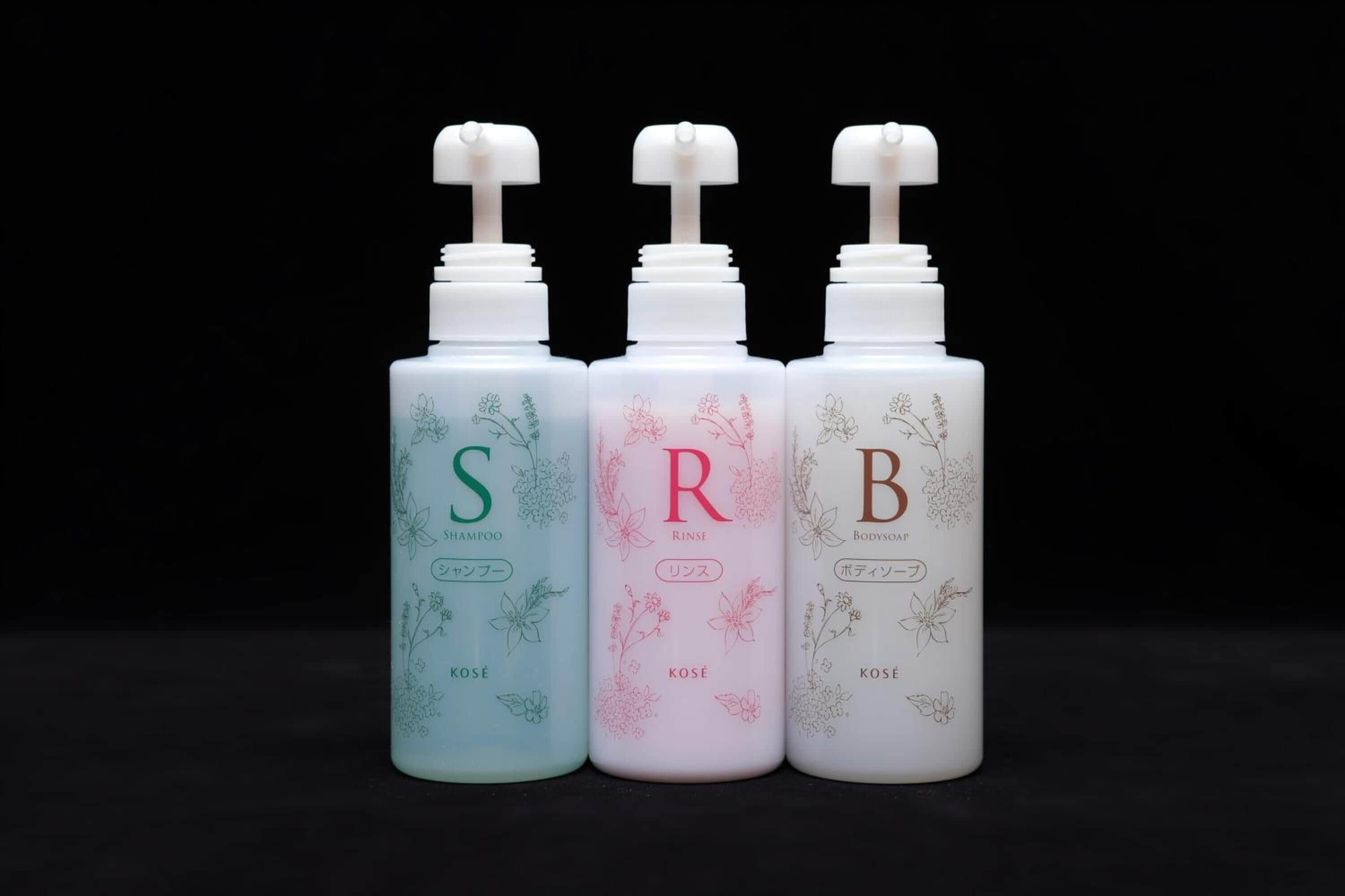 Three bottles with pump dispensers, each labeled with a letter and a word in different colors.
