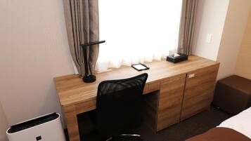 Una habitación de hotel con un escritorio de madera, una silla de oficina negra, una mesita de noche y una cama.