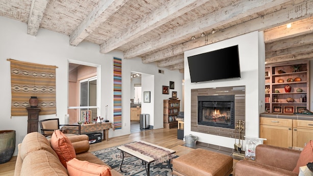 A spacious living room with a fireplace, a large flat-screen TV, and a cozy seating area.