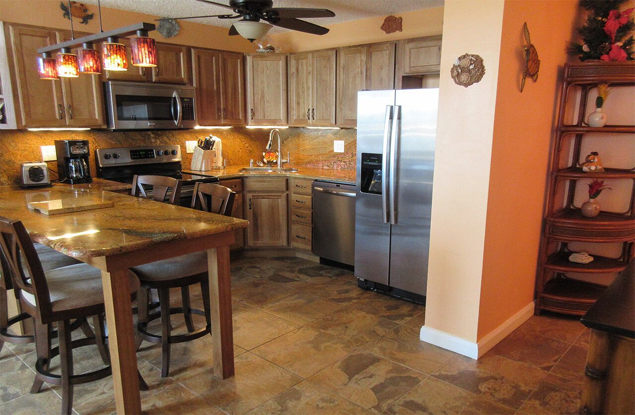 A kitchen with wooden cabinets, a stainless steel refrigerator, a microwave, and a coffee maker.