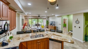 A modern kitchen with granite countertops, wooden cabinets, and a built-in dishwasher.
