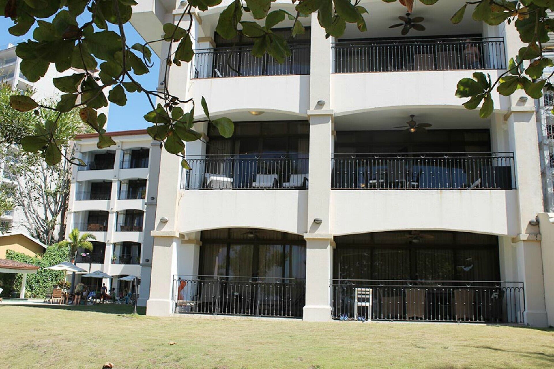 A multi-story building with balconies, large windows, and a flat roof.