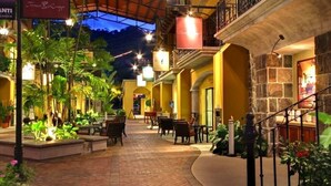 An indoor courtyard with a covered walkway, outdoor seating, and a stone wall.