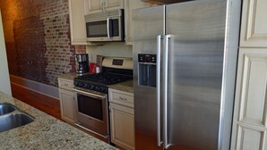 A kitchen with stainless steel appliances, a microwave, a stove, and a refrigerator.