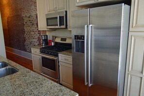 A kitchen with stainless steel appliances, a microwave, and a coffee maker.