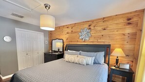 A bedroom with a bed, dresser, nightstand, and a wall clock. - Honey Haus On The Horseshoe - Guadalupe River + Listen to Whitewater Amphitheater Concerts Out Back! (Canyon Lake)