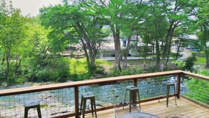 A wooden deck with a view of a pond and surrounding greenery. - Honey Haus On The Horseshoe - Guadalupe River + Listen to Whitewater Amphitheater Concerts Out Back! (Canyon Lake)