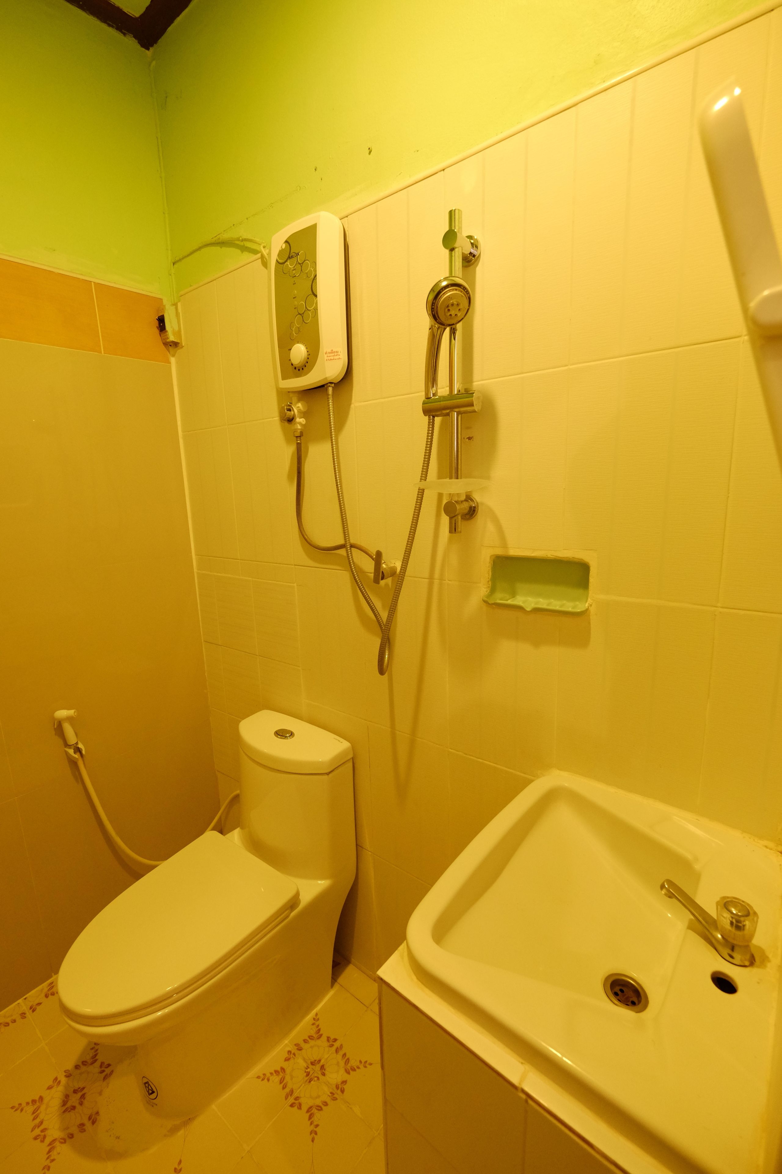 Un baño con inodoro, lavamanos y ducha.