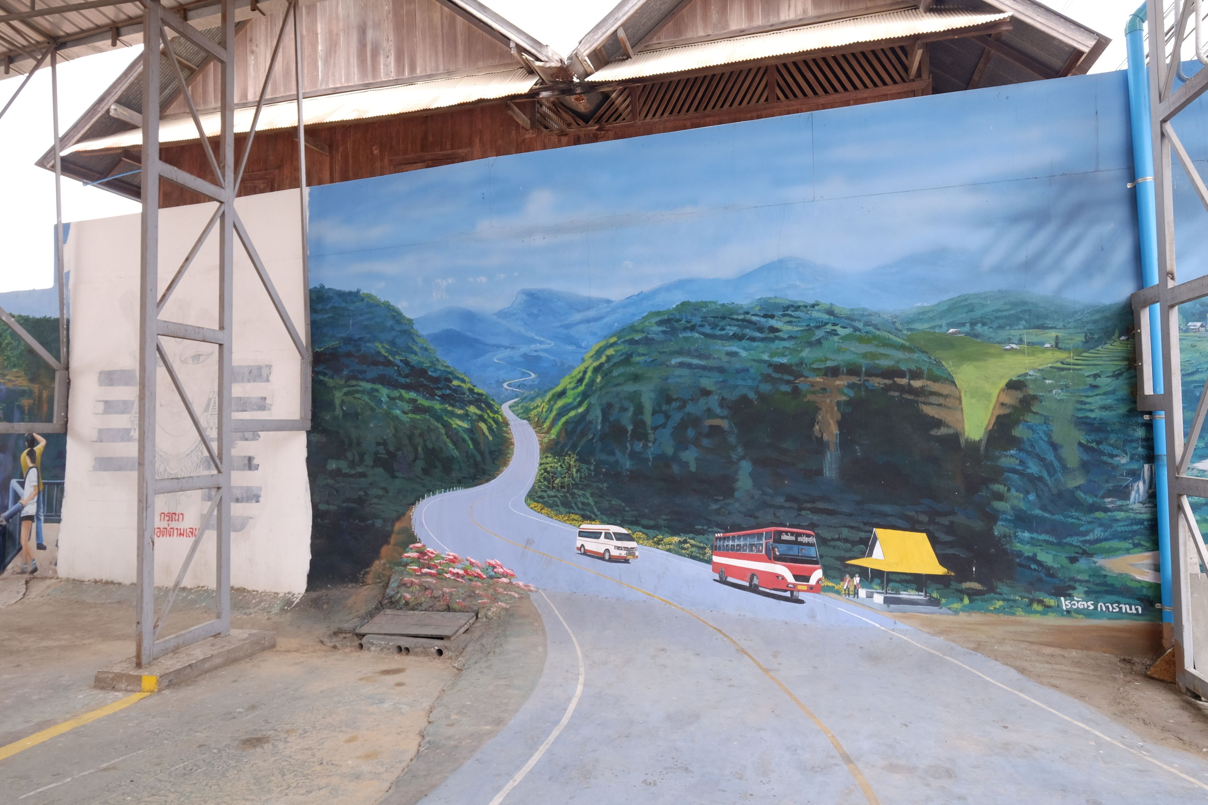 A mural of a winding road through a mountainous landscape.